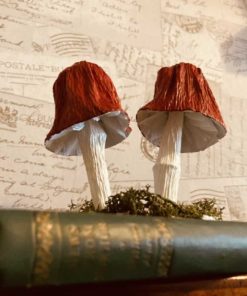 Paper red bell shaped mushrooms in a book