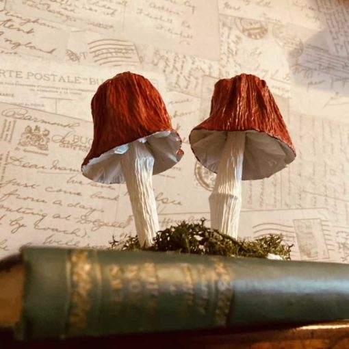 Paper red bell shaped mushrooms in a book