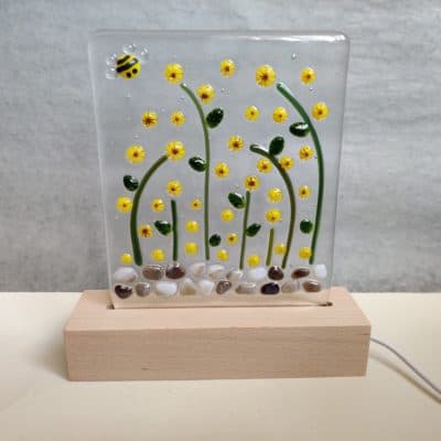 Clear fused glass panel with sunflowers and a bee in a wooden block