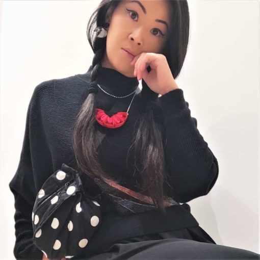 model wearing a spotty belt bag and red necklace