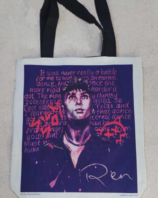 Tote bag with illustrated portrait, artistic text background, black handles, and the signature "Ren" at the bottom.