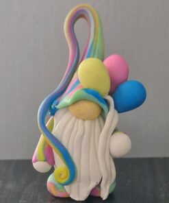 Rainbow clay gnome figure with a white beard, holding colorful balloons, on a gray background.