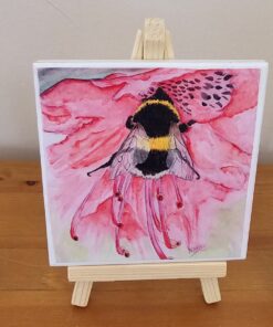 Watercolor painting of a bumblebee on a pink flower, displayed on a small wooden easel.