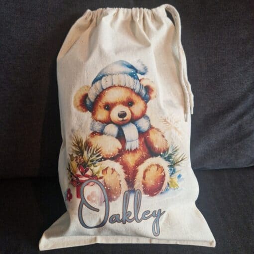 Festive teddy bear bag with "Oakley" text, custom Christmas teddy bear design, perfect for holiday accessories and gifts.