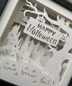 Paper art with a Halloween theme, featuring jack-o'-lanterns, a haunted house, ghostly hands, and a 