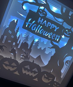 Illuminated Halloween scene with pumpkins, a haunted house, spooky hands, trees, and a 