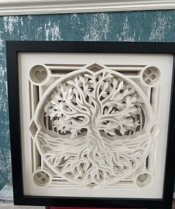 Framed 3D paper art of a tree of life with intricate roots and branches, set against a teal textured wall.