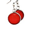 Two red circular earrings with silver edges and hooks, hanging on a black rod.