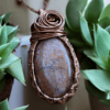 Handmade stone jewelry pendant among green plants, perfect Valentines gifts for her.