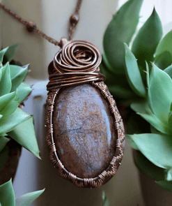 Handmade stone jewelry pendant among green plants, perfect Valentines gifts for her.