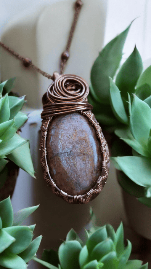 Handmade stone jewelry pendant among green plants, perfect Valentines gifts for her.