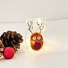 Festive reindeer decoration with lights alongside pinecones and a red ornament on a white background.