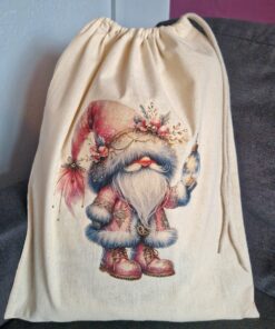 Drawstring bag with a festive gnome design holding a Christmas ornament, featuring a red hat and fur-trimmed outfit.