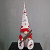 Halloween gnome with a long beard, red and white hat, holding a knife, decorated with spiders and fake blood splatters.