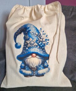 Beige drawstring bag featuring a festive gnome with a blue winter hat adorned with snowflakes and a pom-pom.