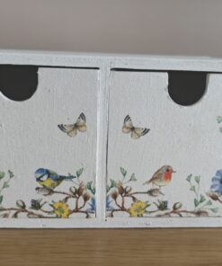 Small white wooden cabinet with two drawers, decorated with floral patterns, birds, and butterflies, placed on a wooden surface.