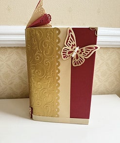 Heart book fold with red and gold cover, with paper flowers inside, and a paper butterfly on the front.