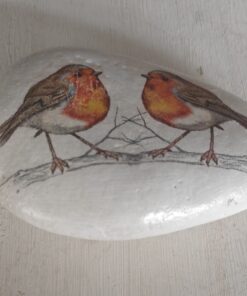 Hand-painted rock featuring two robins perched on a branch against a white background.