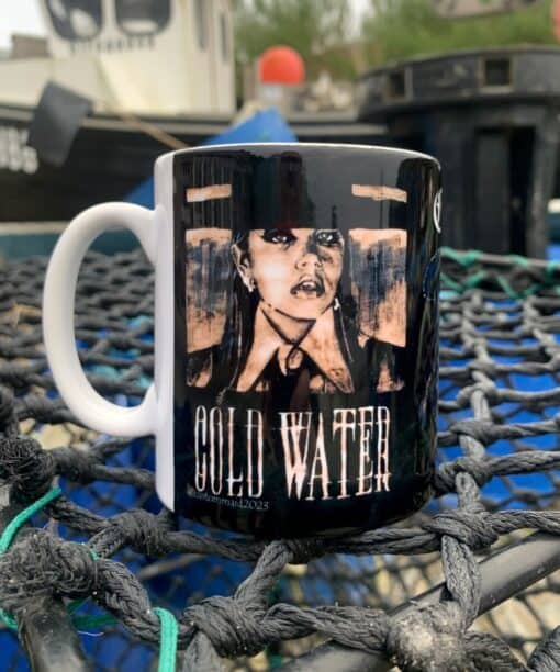 Mug on a net with an edgy black and white portrait and the text "Cold Water" outdoors near boats.