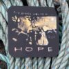 Artwork on black plaque reading "Some people know me as... HOPE" set against a background of woven ropes.