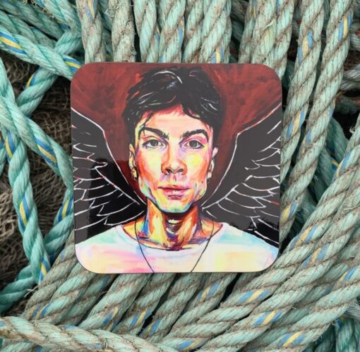 Colorful portrait of a person with angel wings on a coaster, placed on coiled ropes.