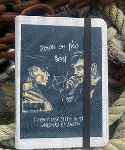 Canvas notebook with illustration and text "Down on the Beat" and "I don't lose sleep in the whispers of sheep" on cover.