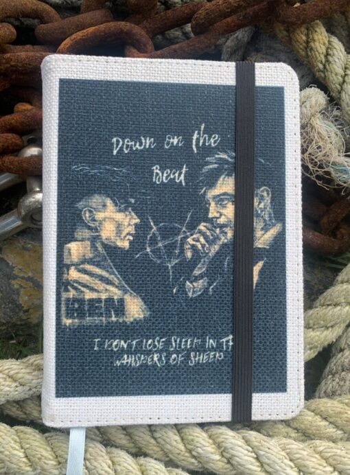 Canvas notebook with illustration and text "Down on the Beat" and "I don't lose sleep in the whispers of sheep" on cover.