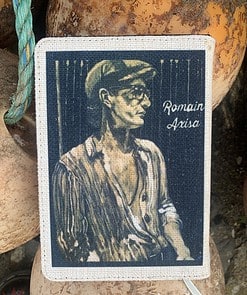 Vintage-style portrait of a man in a cap, titled "Romain Axisa," on a textured surface.