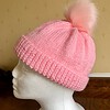 Hand knitted hat in a beautiful pink DK yarn, with a synthetic removable pom pom. Will fit most adults.
