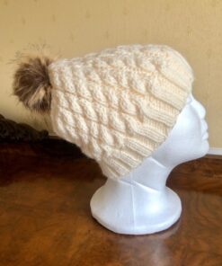Hand knitted, cabled hat in cream Aran, with a removable synthetic pom pom in brown.