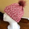 Hand Knitted hat in a mottled pink with a removable pink synthetic pom pom