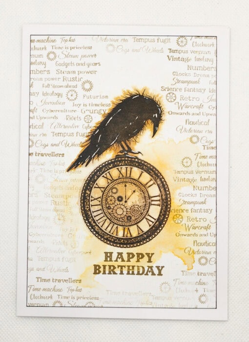 Steampunk-themed birthday card with a black crow perched on a clock, surrounded by vintage-style text and patterns. "Happy Birthday" at bottom.