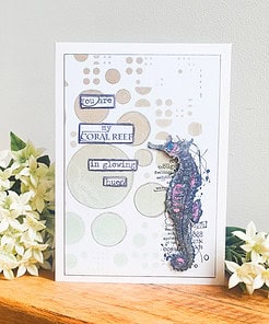 Handmade card with a seahorse and text: "You are my coral reef in glowing hues," surrounded by flowers.