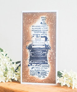 Father's Day card with a typewriter illustration, motivational text, and white flowers on a wooden surface.