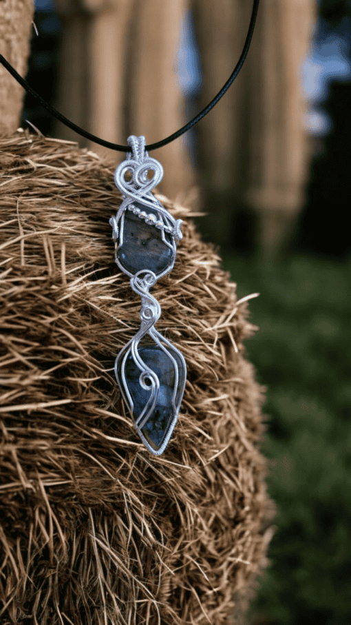 Handcrafted boho pendant with black and white striped stone hangs on a haystack. Statement jewellery with natural stone.