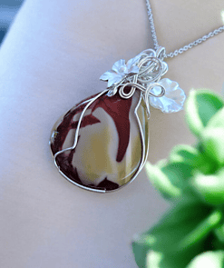 Elegant wire wrap jewelry designs featuring a handmade pendant with a red and yellow stone, adorned with delicate flowers.