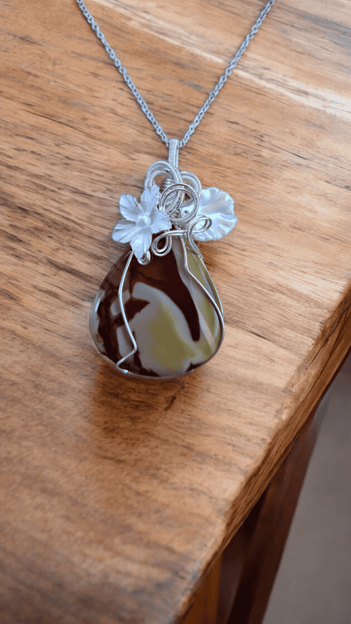 Boho-chic wire wrap necklace features nature-inspired design with floral elements and luxury wire wrapped around a polished stone.