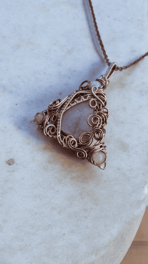 Handmade wire-wrapped jewellery featuring a floral design with a gray stone and intricate copper detailing, ideal for gifts.