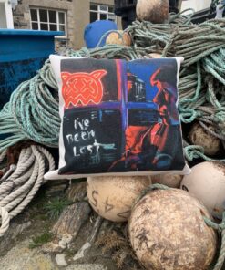 A pillow with graffiti art design on ropes and fishing buoys, background of stone building and blue bins.