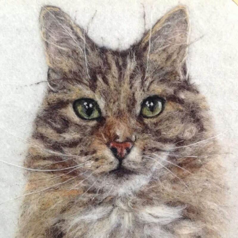 Detailed portrait of a tabby cat with green eyes, drawn using realistic textures on a light background.