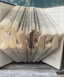 An open book with pages folded to spell 