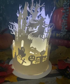 Halloween-themed paper lantern with cut outs of a witch, ghost, pumpkins, and a haunted castle, lit from within.