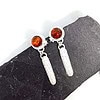 Silver drop earrings with round amber stones and star accents, displayed on a dark slate background.